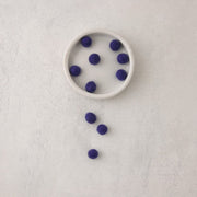 blue felt beads in bowl