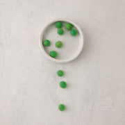 green felt beads arranged in a bowl